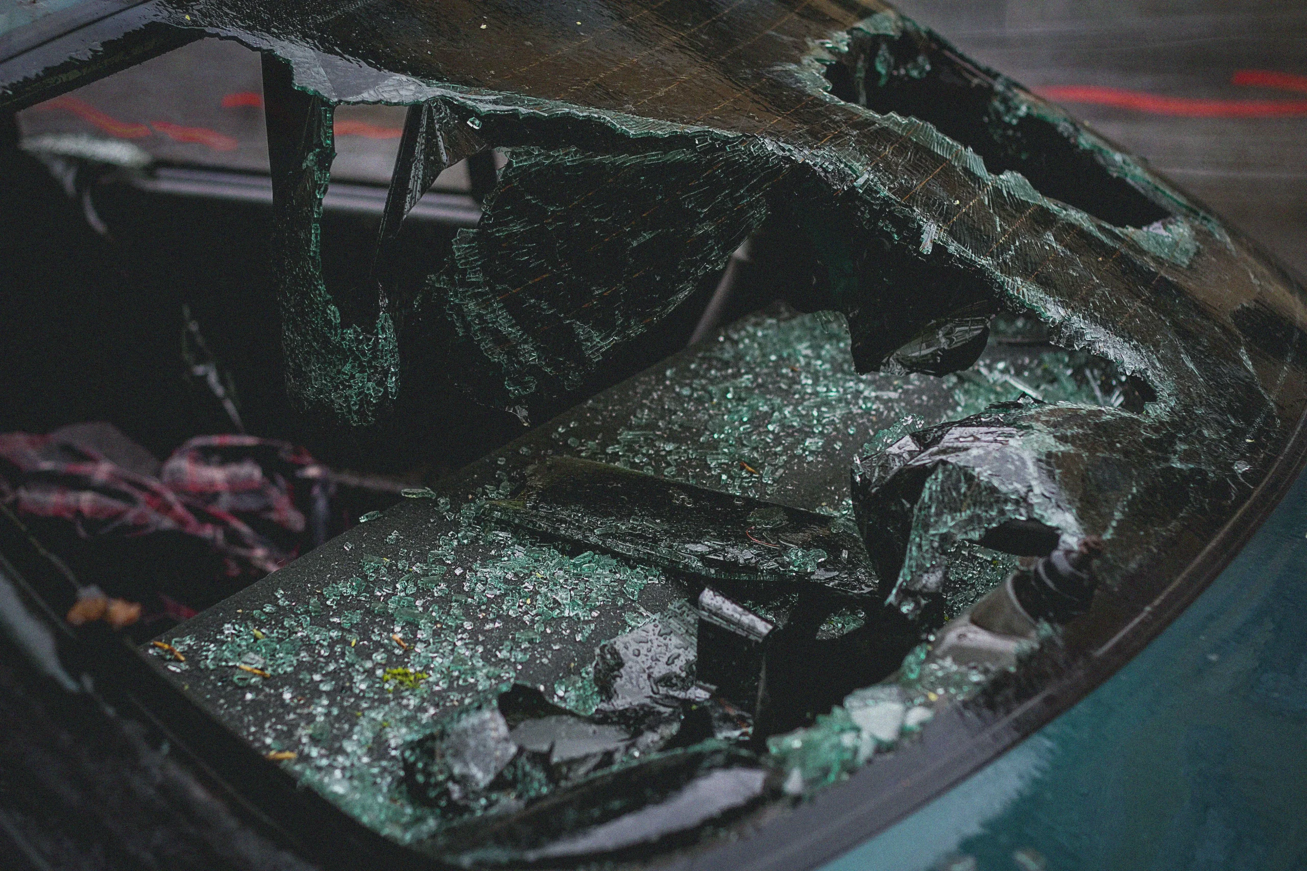Close-up of shattered rear windshield glass on a car.