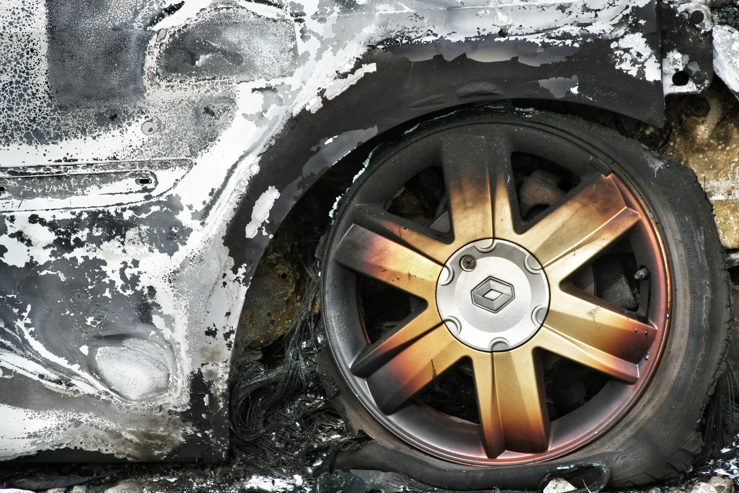 Close-up of a burned wheel on a car that has been damaged by fire.